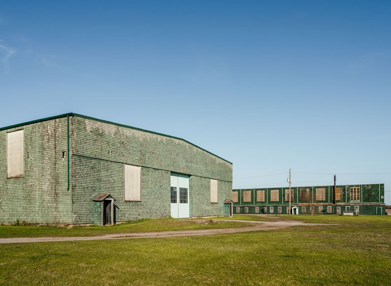 campsite Large hanger and storage buidling in faded green at Base31
